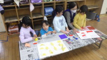 子どもたちが折り紙を折っている様子の写真